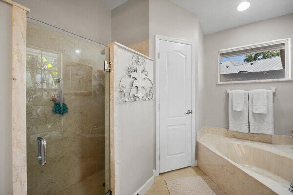 bathroom featuring shower with separate bathtub