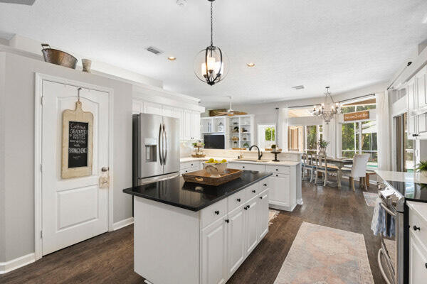 kitchen featuring appliances with stainless steel finishes, hanging light fixtures, kitchen peninsula, and white cabinets