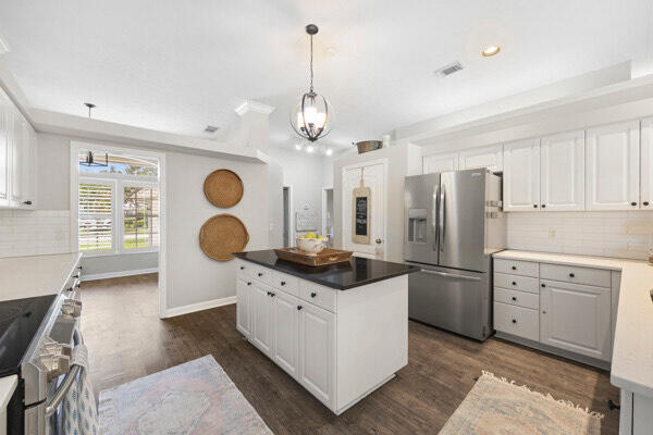 kitchen featuring stainless steel appliances, backsplash, dark hardwood / wood-style flooring, and white cabinetry