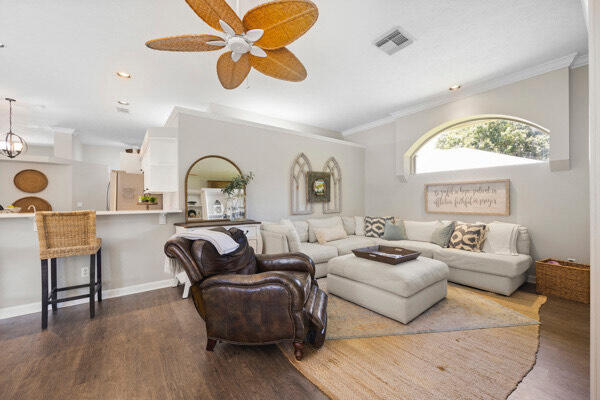 living room featuring ceiling fan, crown molding, and dark hardwood / wood-style flooring