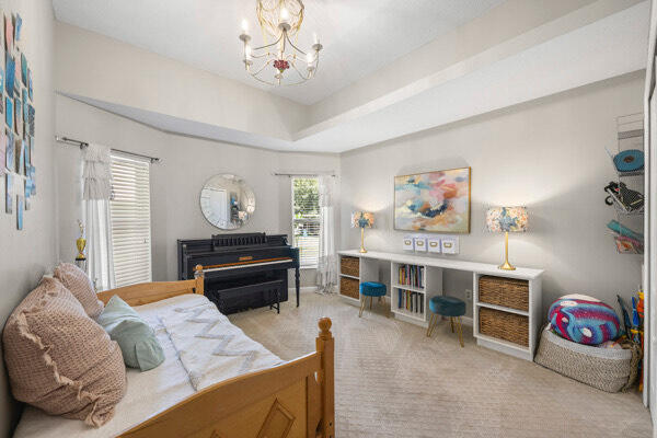 bedroom featuring light carpet and a notable chandelier