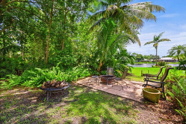 view of yard featuring a fire pit, a water view, and a patio area