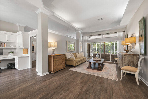 living room featuring ornamental molding, dark hardwood / wood-style floors, and ornate columns