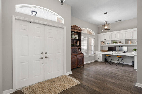 entrance foyer featuring built in desk and dark hardwood / wood-style flooring