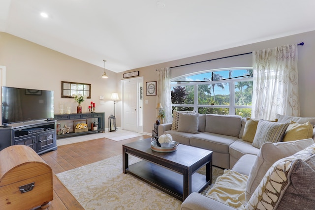 living room with light wood-type flooring and vaulted ceiling