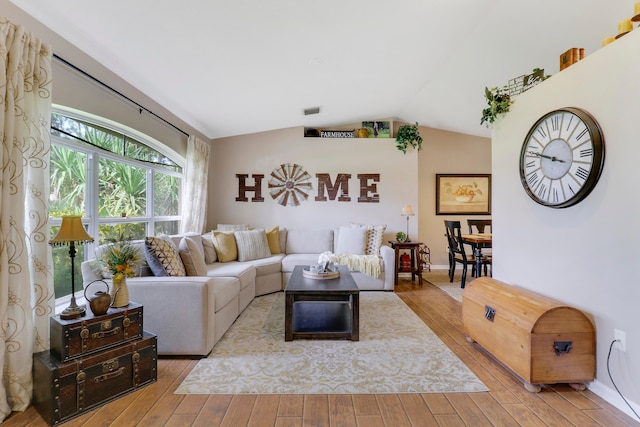 living room with light hardwood / wood-style flooring and vaulted ceiling