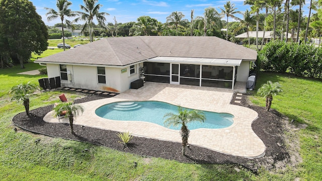 rear view of house with a patio, a yard, and a sunroom