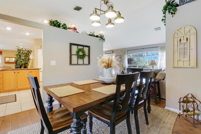 dining area featuring light hardwood / wood-style flooring and a chandelier