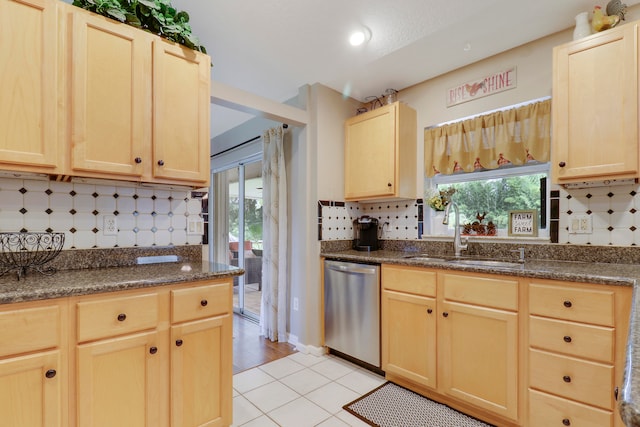 kitchen with sink, backsplash, light tile patterned floors, light brown cabinetry, and stainless steel dishwasher