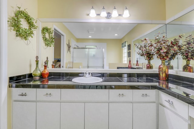 bathroom with vanity and a shower with shower door