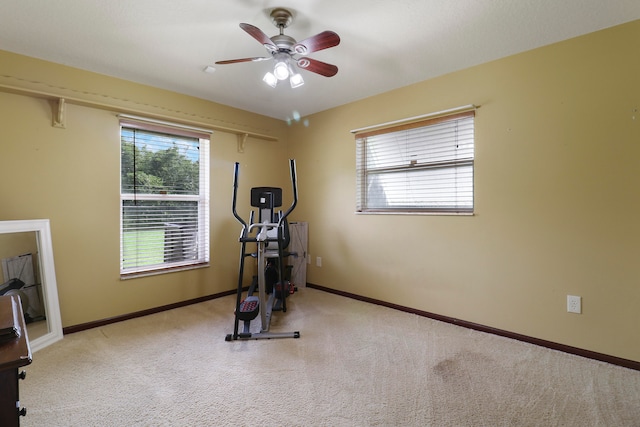 workout room featuring ceiling fan and light colored carpet