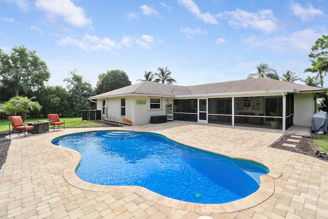 view of pool with a sunroom, central AC, and a patio area