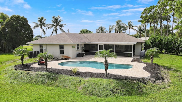 rear view of property with a sunroom, a yard, and a patio