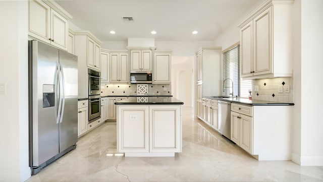 kitchen featuring stainless steel appliances, cream cabinets, and sink