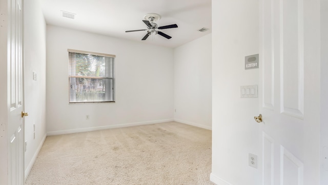 spare room with light colored carpet and ceiling fan