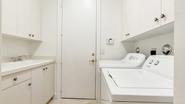 laundry area with cabinets, sink, washing machine and clothes dryer, and light tile patterned floors