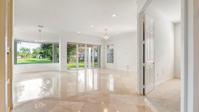 unfurnished room featuring light carpet, ornamental molding, an inviting chandelier, and plenty of natural light