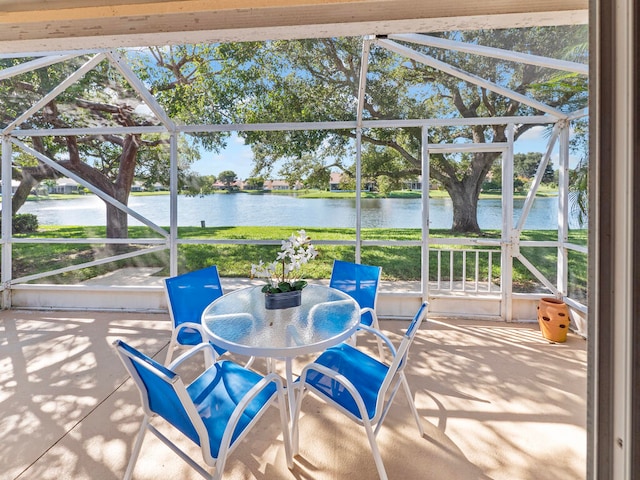 sunroom featuring a water view