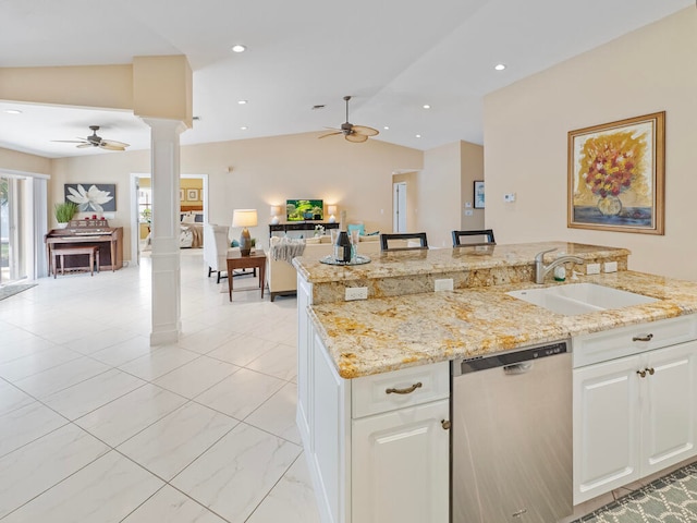 kitchen with stainless steel dishwasher, vaulted ceiling, ornate columns, and white cabinets