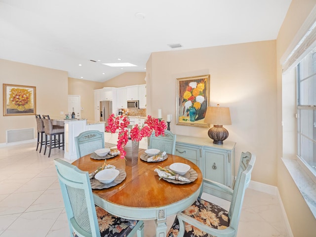 dining space featuring vaulted ceiling