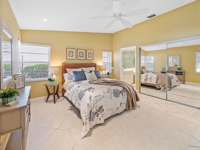 tiled bedroom with a closet, ceiling fan, vaulted ceiling, and ensuite bathroom