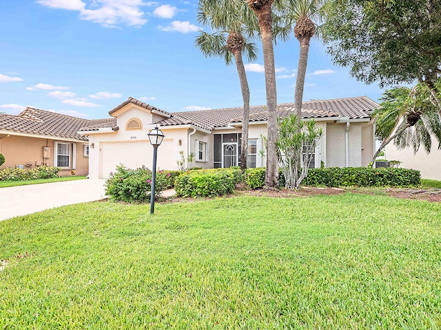 mediterranean / spanish-style home with a front yard and a garage