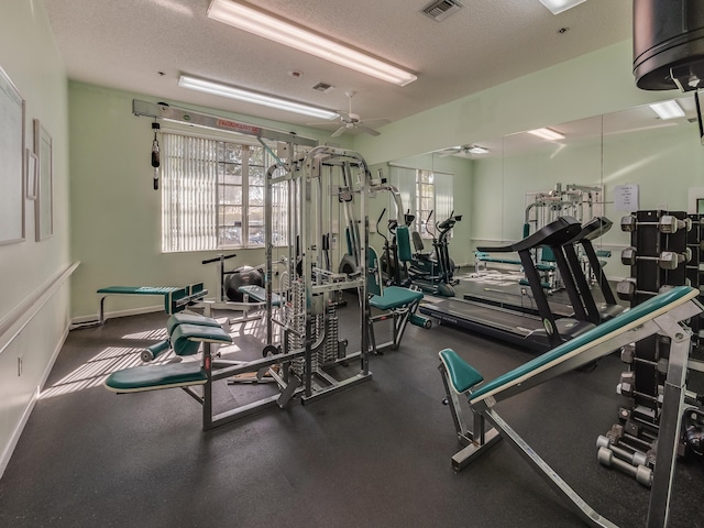 gym with a textured ceiling and ceiling fan