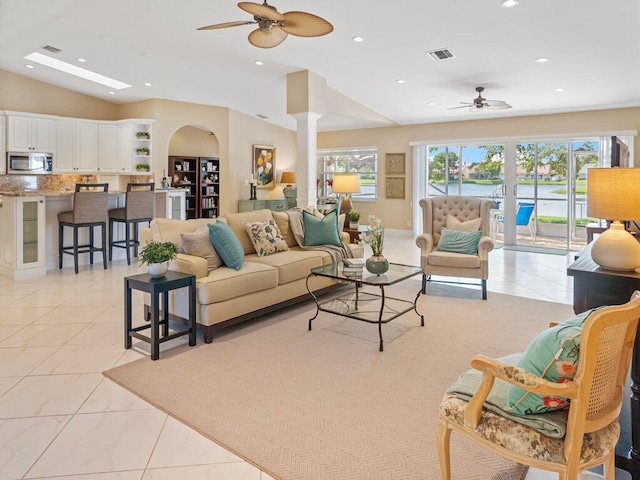 tiled living room with ceiling fan and lofted ceiling