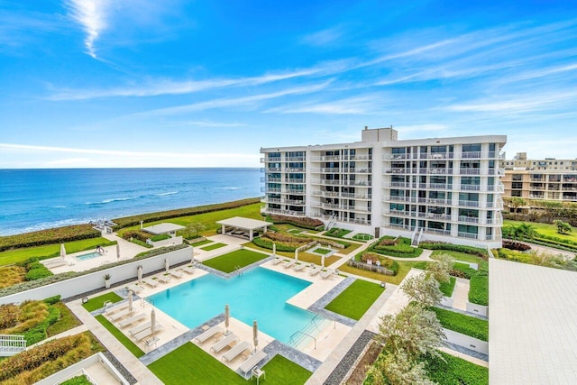 view of pool featuring a water view, a patio, and a yard