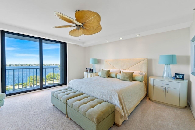 carpeted bedroom with access to outside, a water view, and ceiling fan