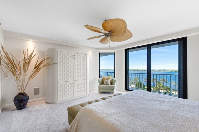 bedroom with carpet floors, a water view, access to outside, and ceiling fan