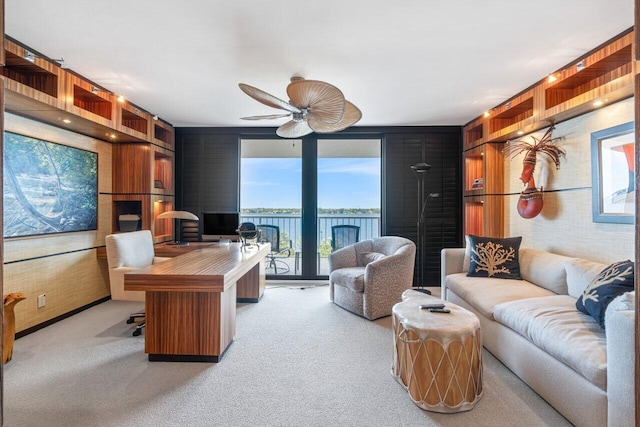 office area with light carpet, wood walls, and ceiling fan