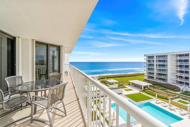 balcony with a water view and a view of the beach