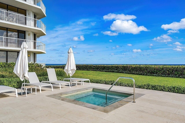 view of swimming pool featuring an in ground hot tub, a patio, a water view, and a lawn