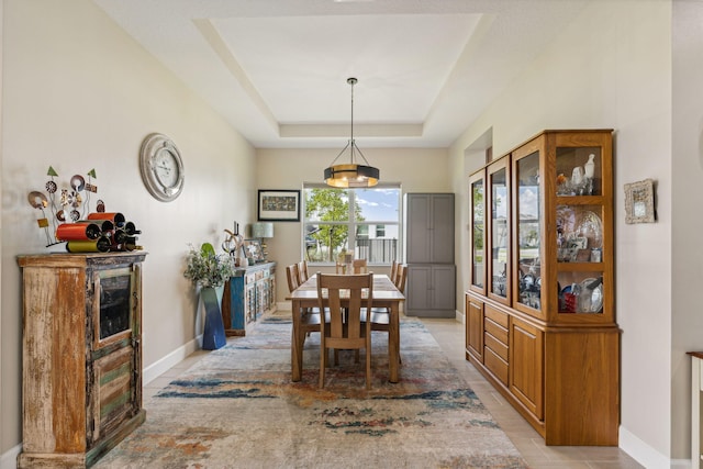 dining space with a raised ceiling