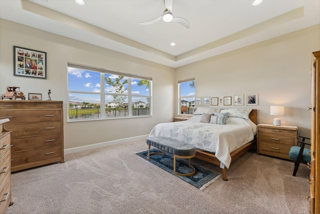 bedroom featuring a tray ceiling, ceiling fan, and light colored carpet