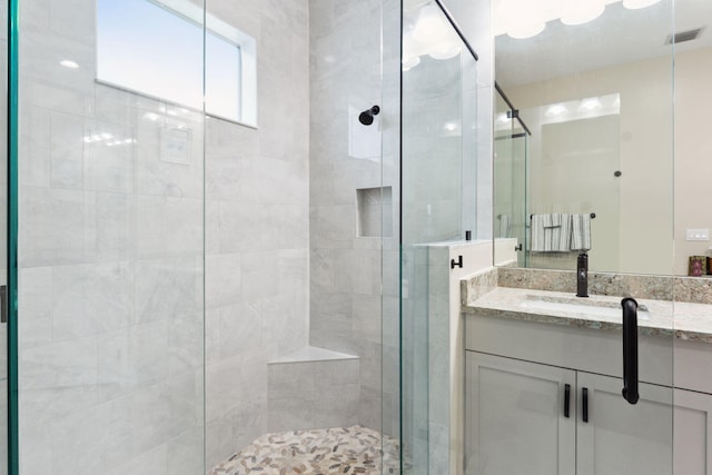 bathroom featuring walk in shower and vanity