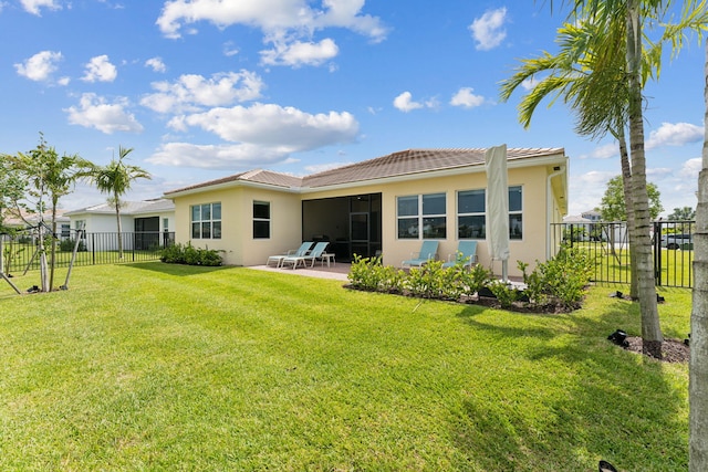 back of house featuring a patio and a yard