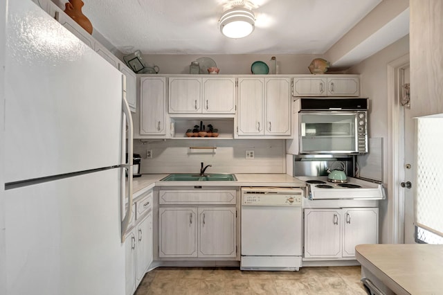 kitchen featuring backsplash, sink, white cabinets, and white appliances