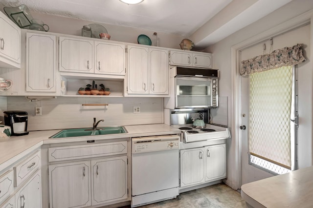 kitchen featuring white cabinetry, backsplash, white dishwasher, and sink