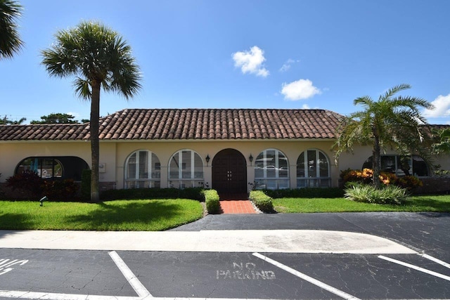 mediterranean / spanish home with a front lawn