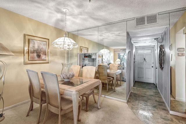 dining space with a textured ceiling and a chandelier