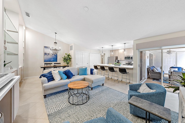 tiled living room featuring ceiling fan with notable chandelier and vaulted ceiling