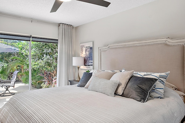 bedroom featuring ceiling fan, access to exterior, and a textured ceiling