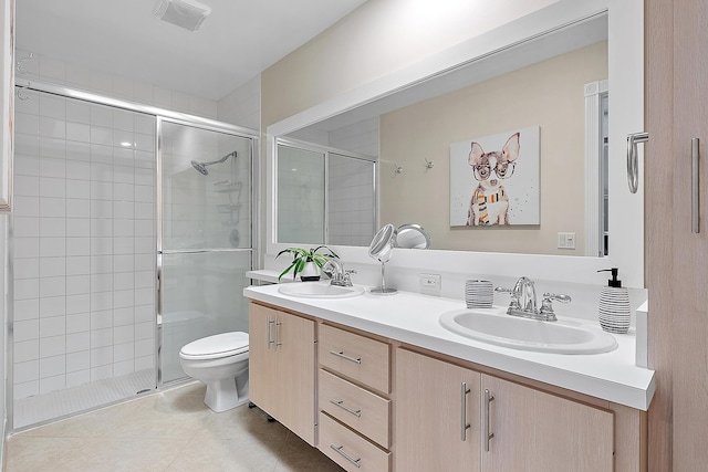 bathroom with tile patterned floors, vanity, an enclosed shower, and toilet