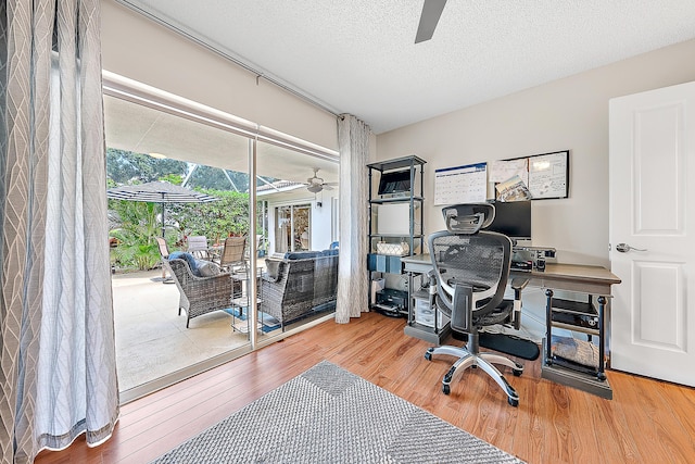 office featuring wood-type flooring, a textured ceiling, and ceiling fan