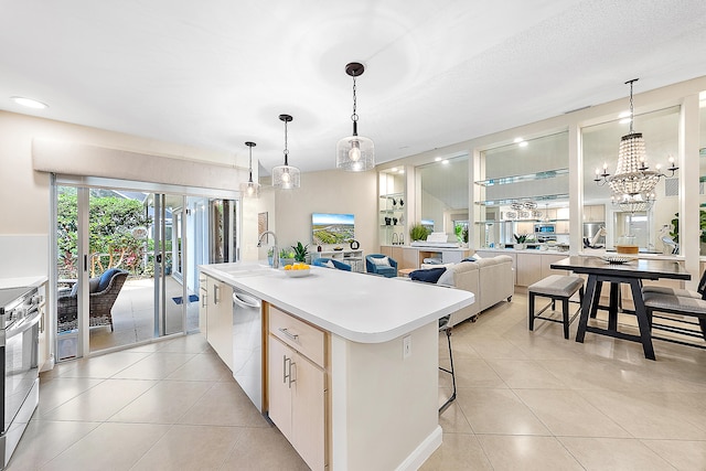 kitchen featuring a center island with sink, decorative light fixtures, sink, and stainless steel appliances