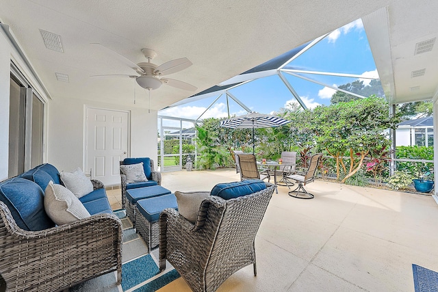 view of patio with outdoor lounge area, ceiling fan, and glass enclosure