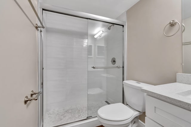 bathroom featuring vanity, toilet, and a shower with door