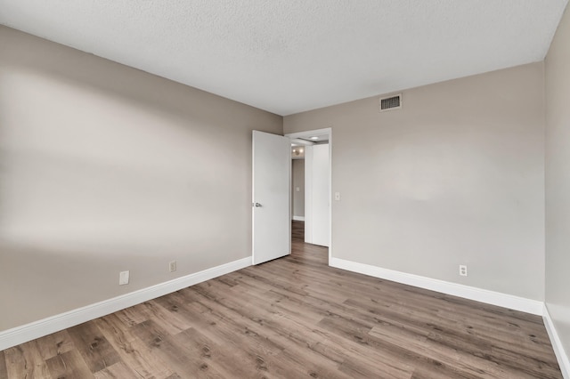 empty room featuring light hardwood / wood-style floors and a textured ceiling